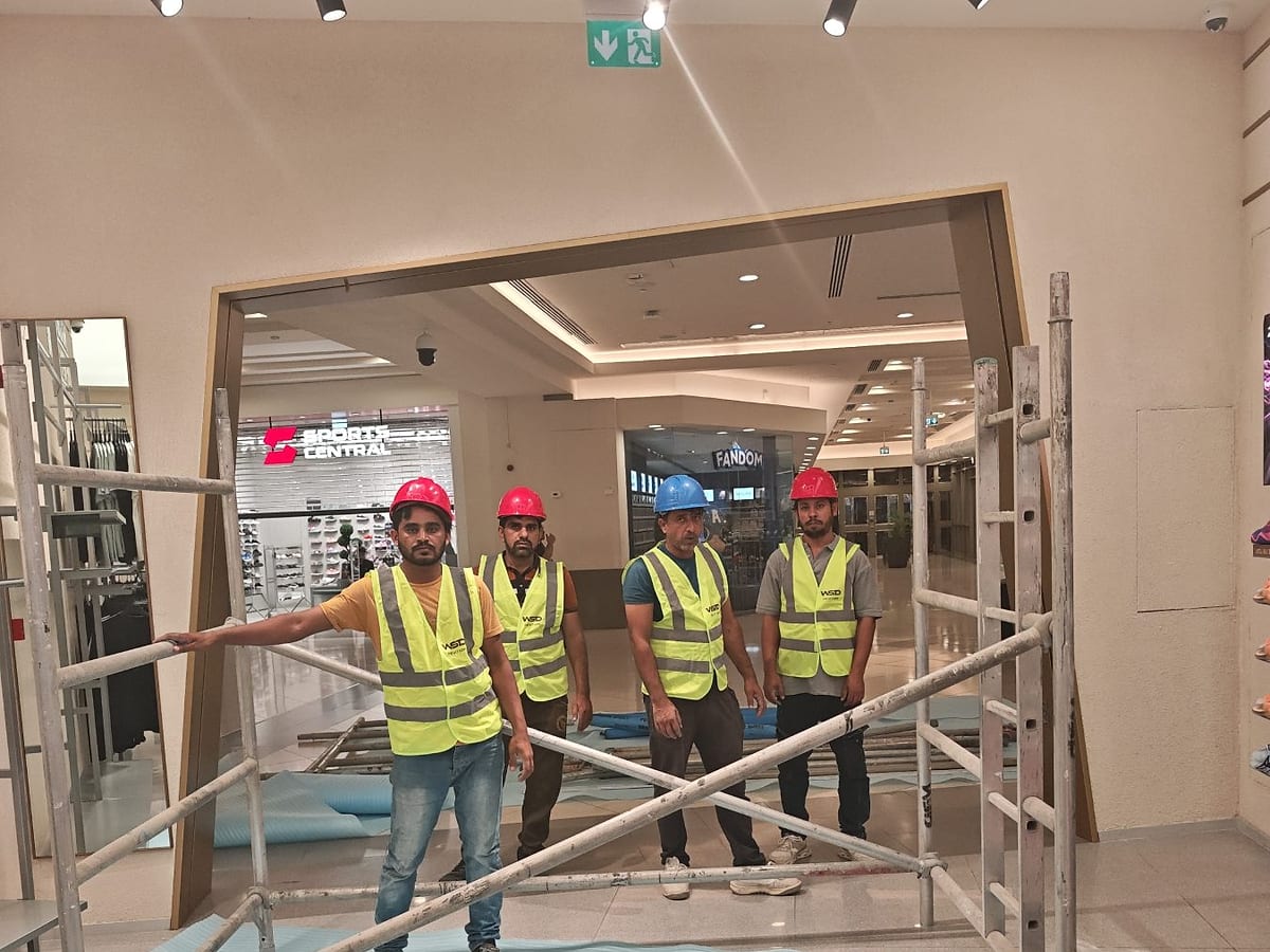Four WSD site team members wearing hard hats and branded high-visibility vests at the ANTA Deira City Centre fit-out